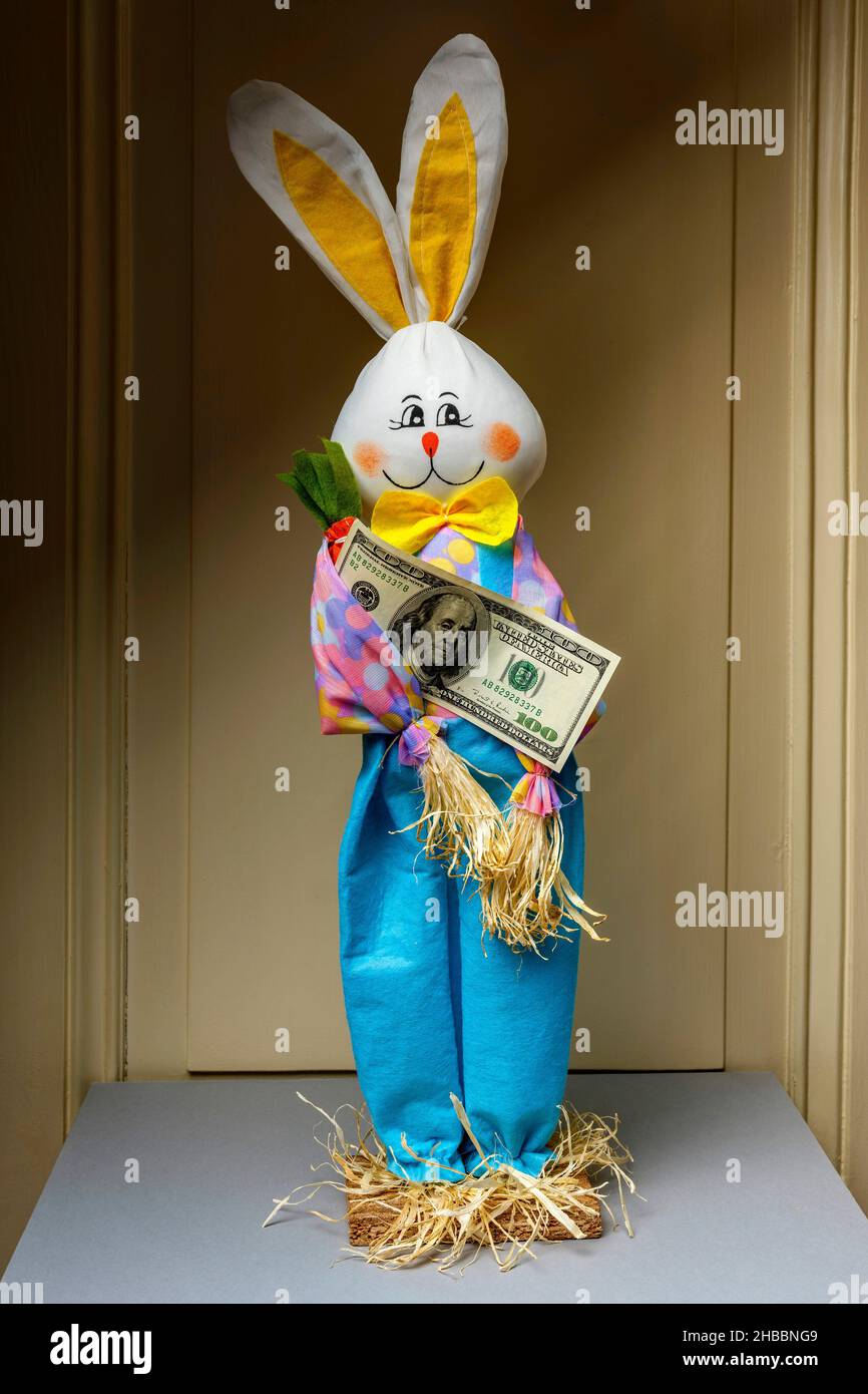 Coniglio felice imbottito che detiene 1 banconote da cento dollari, Foto Stock