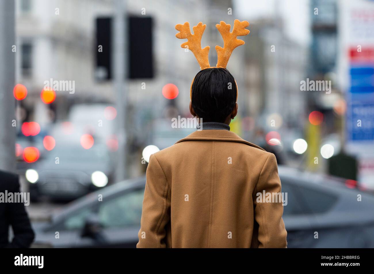 Londra, Regno Unito. 18 dicembre 2021. Una donna che indossa la bretella natalizia scende lungo la Brompton Road. 93.045 nuovi casi di coronavirus sono stati segnalati il giorno precedente e i casi della variante Omicron sono aumentati in misura tale che il governo del Regno Unito si trova di fronte all'attuazione di restrizioni più severe del piano C per frenarne la diffusione; Come il divieto di mescolare al chiuso tra le famiglie e il divieto di ospitalità al chiuso, che possono avere ripercussioni sul periodo natalizio. Credit: Stephen Chung / Alamy Live News Foto Stock