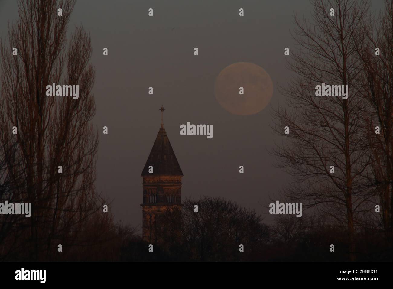 Micro Moon, la Luna fredda di dicembre visto da Town Moor a Newcastle con l'iconico campanile Tower of the Church of St George a edificio classificato di grado 1, Newcastle upon Tyne, Regno Unito, 18th dicembre 2021, Credit: RUGIADA/Alamy Live News Foto Stock