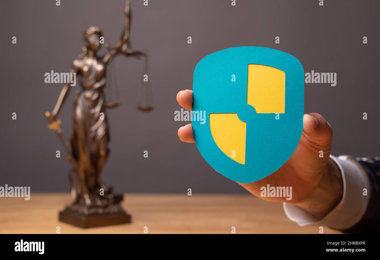 Fuoco selettivo di un segno scudo di sicurezza e una statua di diritto e giustizia su una superficie di legno Foto Stock Fuoco selettivo di un segno scudo di sicurezza e una statua di diritto e giustizia su una superficie di legno Foto Stock