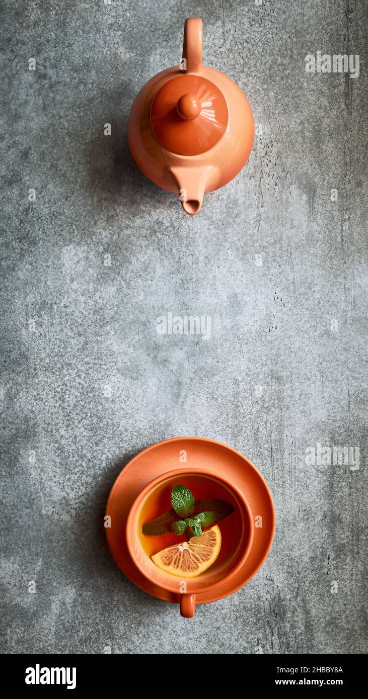 Vista dall'alto verticale della teiera e della tazza da tè su sfondo grigio con spazio per la copia Foto Stock