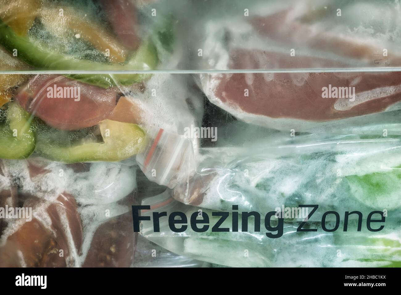 Affettato frutti maturi di peperone in sacchetti di cellophane, preparati per il congelamento e la conservazione a lungo termine nel comparto freezer del frigorifero. V. Anteriore Foto Stock