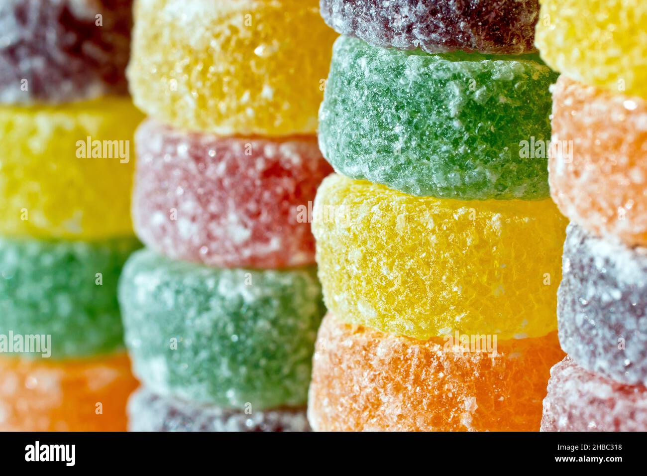 Un primo piano di pile di dolci rotondi, colorati, aromatizzati alla frutta  e zuccherati, comunemente chiamati pastiglie Foto stock - Alamy