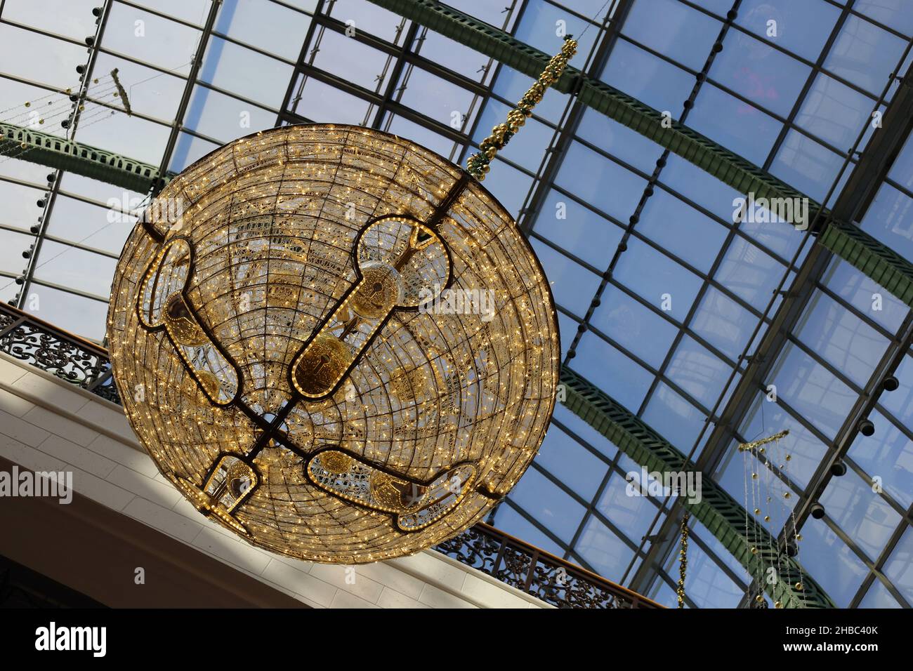 Decorazioni natalizie dorate a forma di campana con piccole e belle luci calde nell'area centrale a cupola del tetto di vetro del Mall of the Emirates, Dubai, Emirati Arabi Uniti. Foto Stock