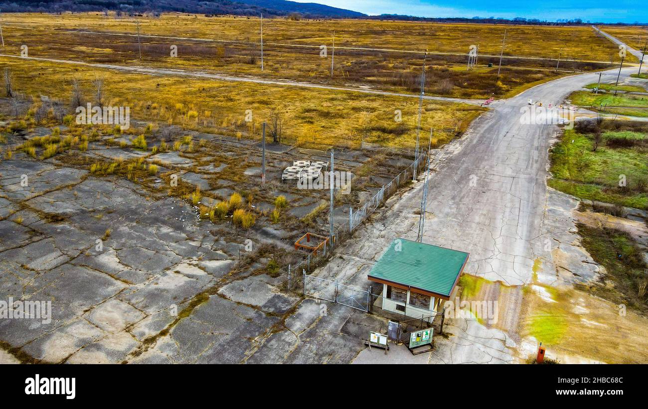 Abbandonate vecchie munizioni cancello fabbrica, massiccia terra piatta rimane Foto Stock