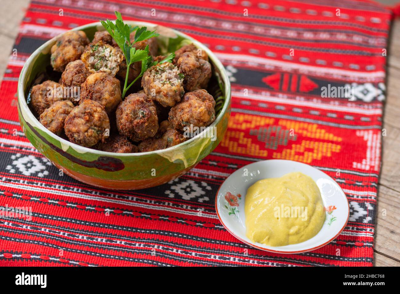 palle di carne fritte in un recipiente di argilla su un panno tradizionale Foto Stock