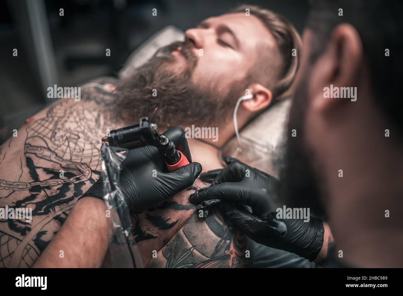 Tatuaggio artista che mostra processo di fare un tatuaggio Foto Stock