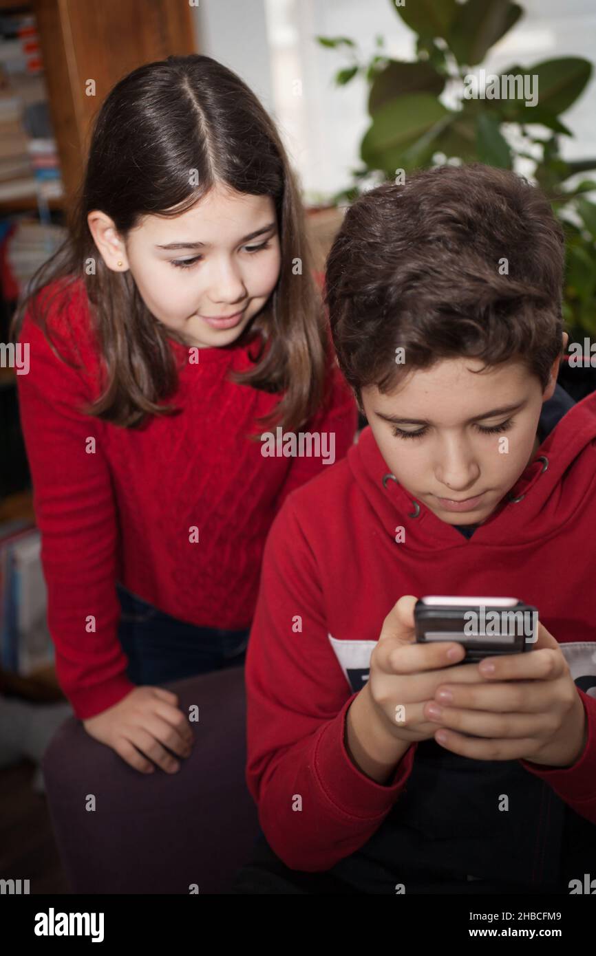 Due bambini che guardano un telefono cellulare Foto Stock