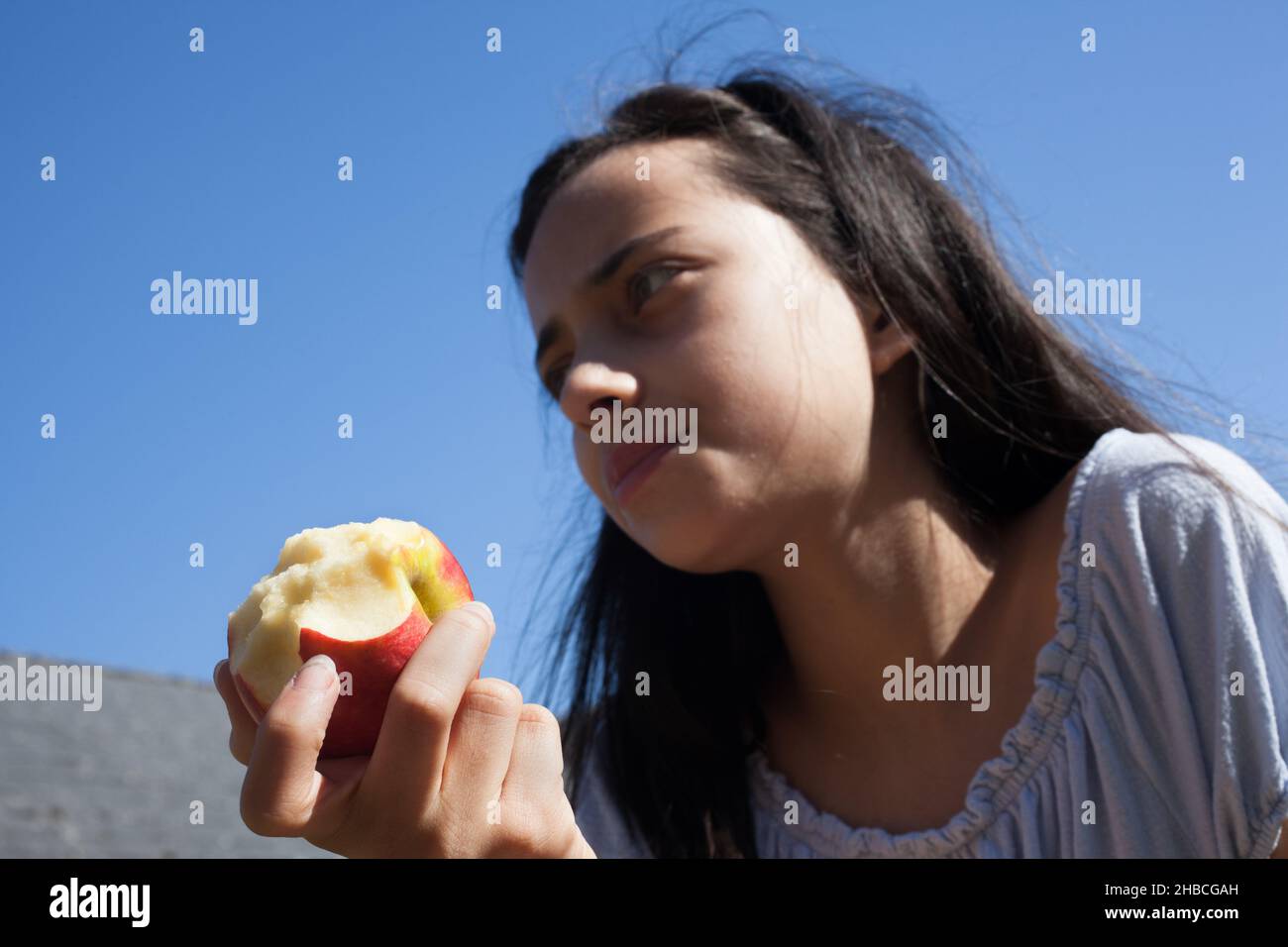Una ragazza di 11 anni che mangia una mela Foto Stock
