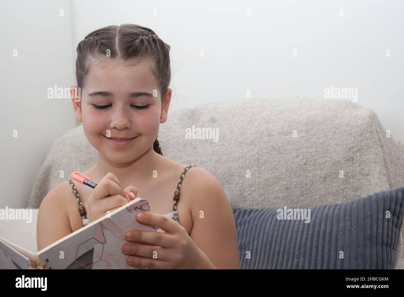 Un bambino felice che scrive nel suo giornale quotidiano Foto Stock