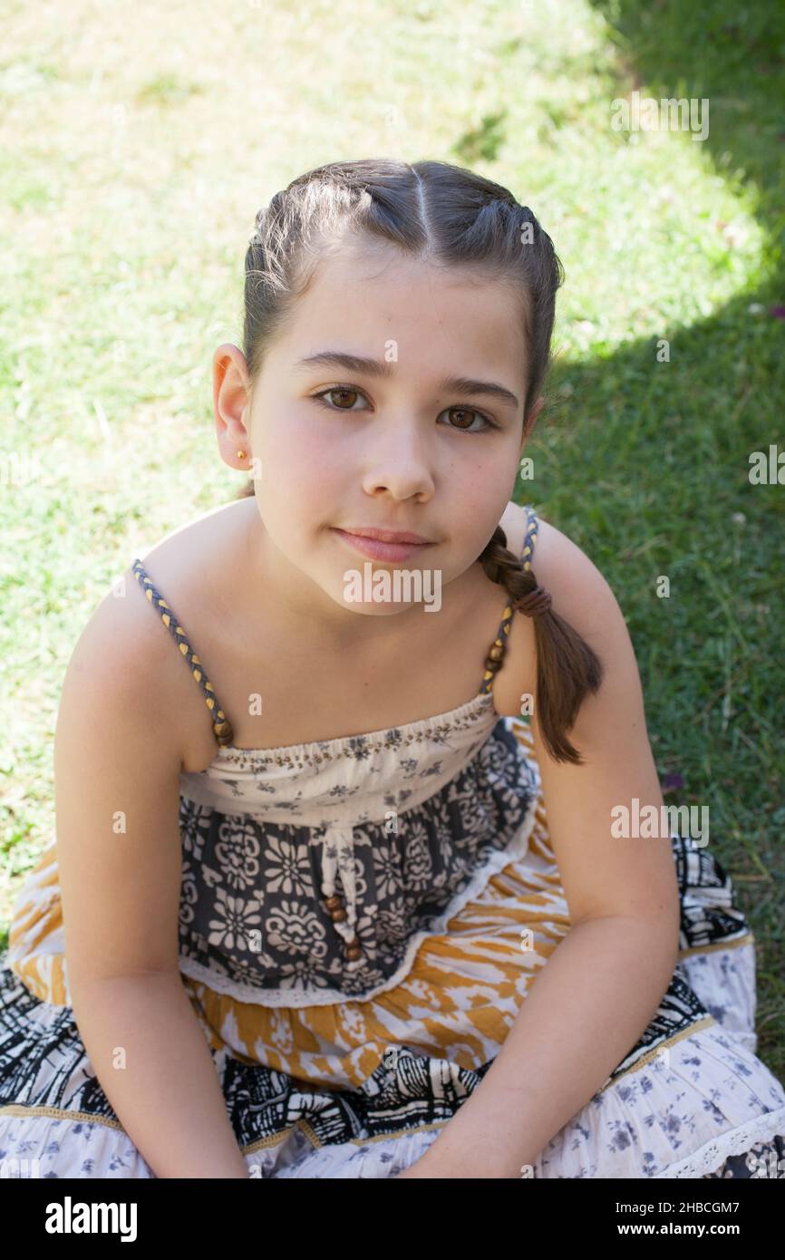 Un ritratto di una bambina di 8 anni al sole in un giorno d'estate Foto Stock