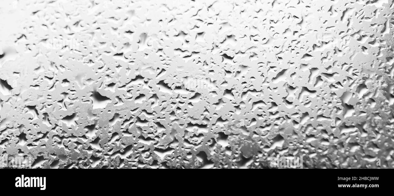 Gocce d'acqua dietro il vetro. Sfondo da gocce di pioggia sulla finestra. Sfondo bianco e nero fatto di gocce d'acqua. Modello creativo Foto Stock