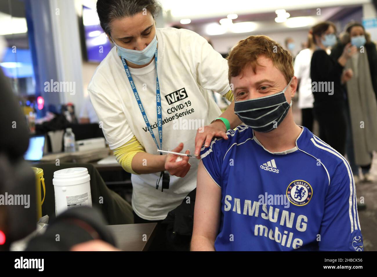 Londra, Regno Unito. 18th Dic 2021. Chris White, 27 anni fan del Chelsea, è stato vaccinato da un membro della squadra di vaccinazione NHS allo stadio del Chelsea. Il Chelsea Stamford Stadium è stato utilizzato come centro di vaccinazione NHS che fornisce una maratona di jab ‘Jabathon’. Le prenotazioni iniziarono dal 10am come membri dell'esercito e dell'NHS fornì la vaccinazione. (Foto di Belinda Jiao/SOPA Images/Sipa USA) Credit: Sipa USA/Alamy Live News Foto Stock