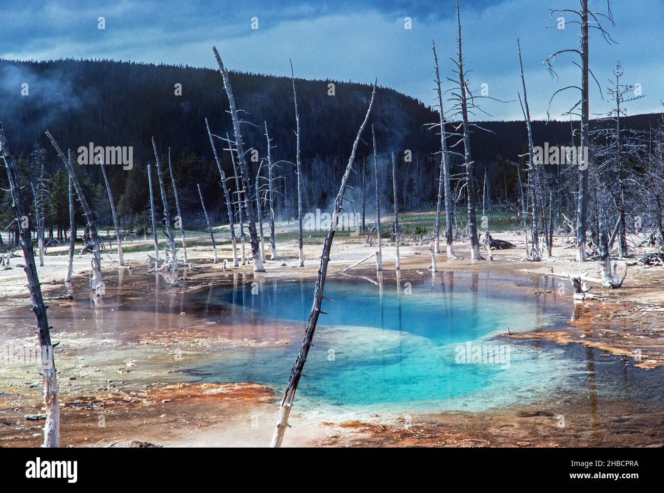 Nuvole minacciose si avvicinano a una piscina termale nel Parco Nazionale di Yellowstone. Foto Stock