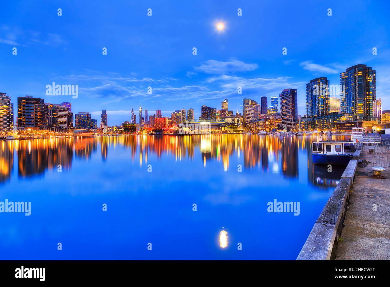 Ancora riflesso di Docklands moderno paesaggio urbano nella città di Melbourne al susnet con luci luminose. Foto Stock