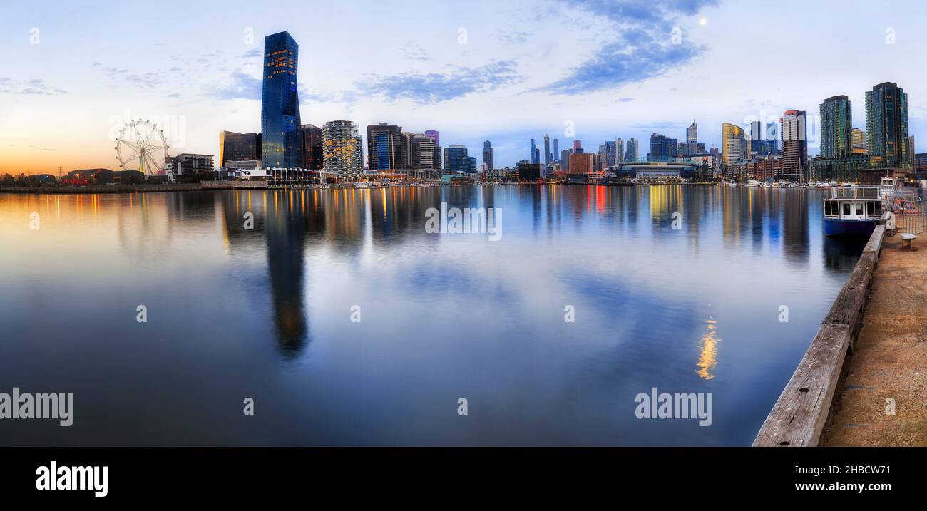 Ampio panorama al tramonto dell'area Docklands della città di Melbourne con riflessi nel fiume di luci Yarra. Foto Stock