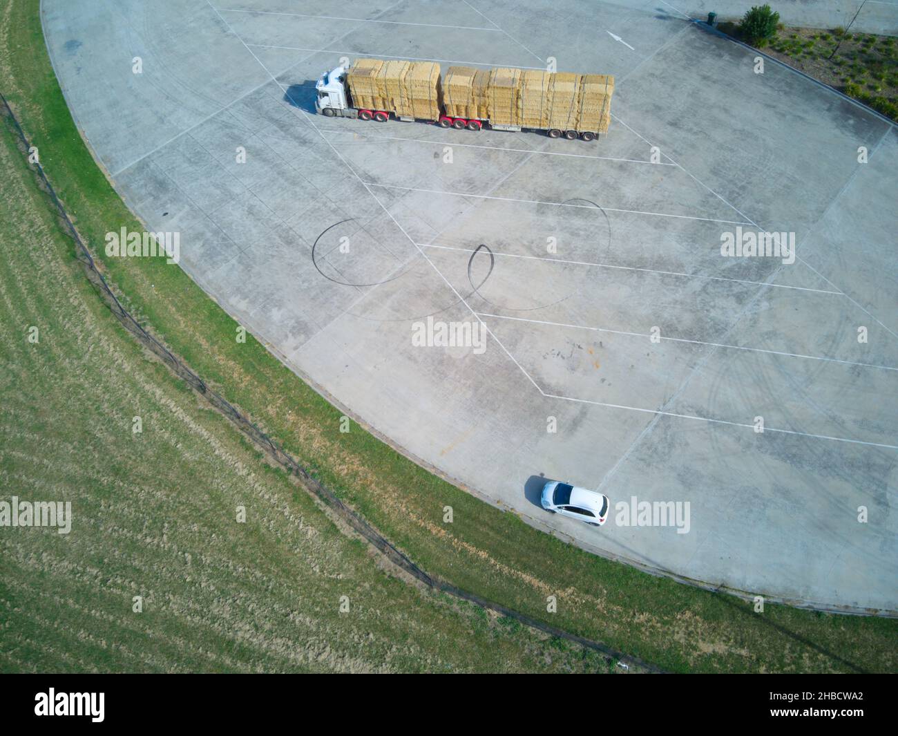 Camion parcheggiato con balle di fieno vista aerea con piccola auto in una fermata di sosta stradale sito, vicino a Melbourne, Victoria, Australia. Foto Stock