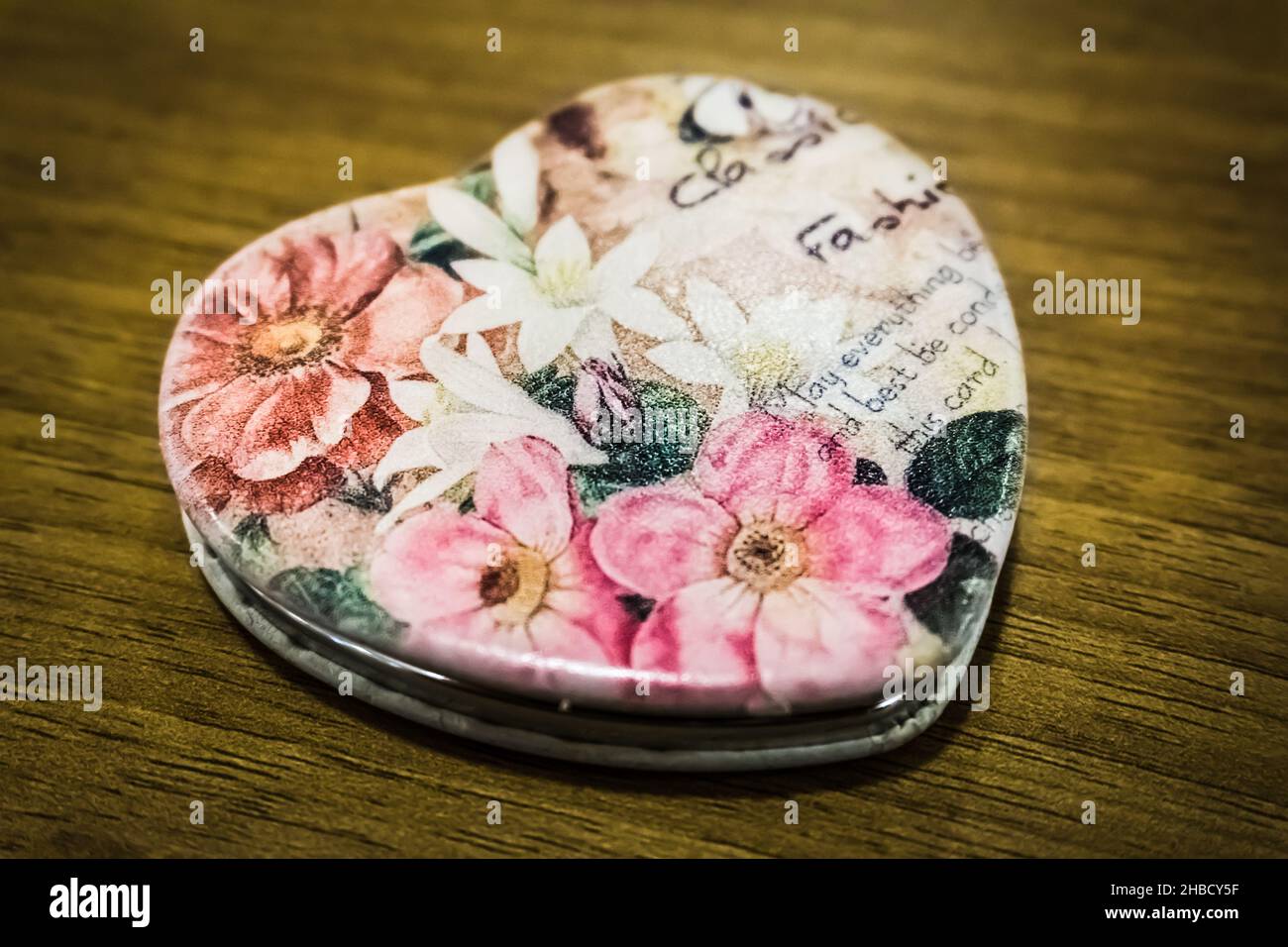 Specchio a forma di cuore su tavola di legno con bei fiori che decorano il  rivestimento ribaltabile, bella bokeh blu illuminazione di colore sullo  sfondo Foto stock - Alamy