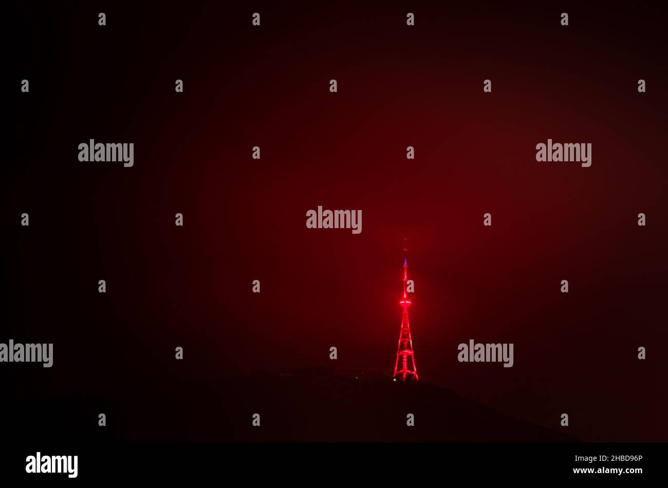 Torre della televisione rossa Illiuminata e funicolare sulla collina a Tbilisi, Georgia. Immagine spazio vuoto di sfondo. 22.03.2020 Foto Stock