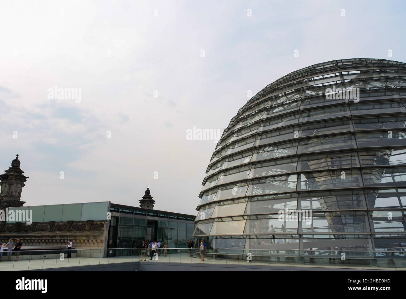 Esterno a cupola Reichstag in estate con luce del sole gialla riflessa su vetro. Popolare attrazione turistica. Nuvole su sfondo cielo blu. Foto Stock