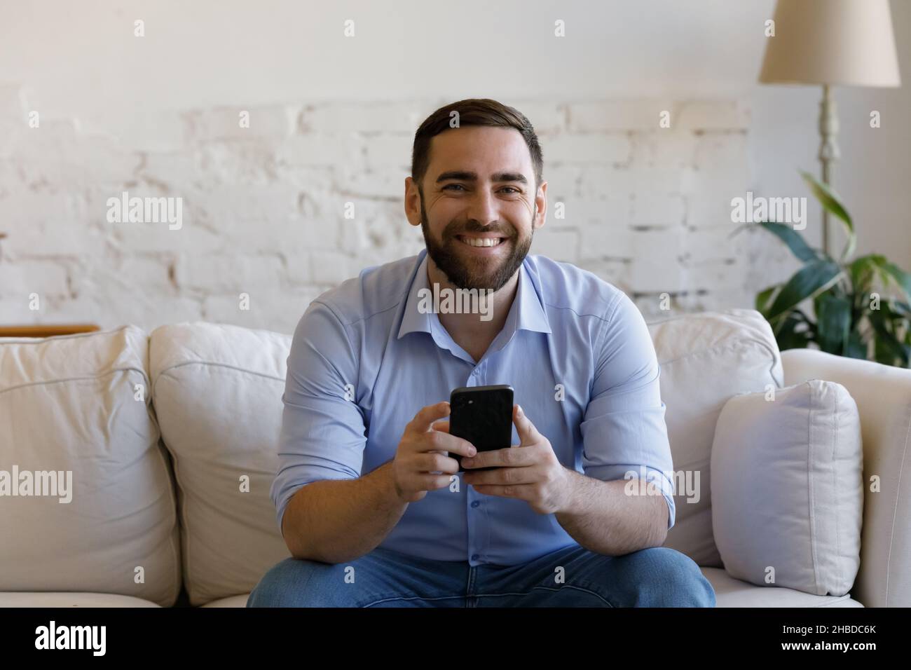 Ritratto di un giovane sorridente con smartphone nelle mani. Foto Stock