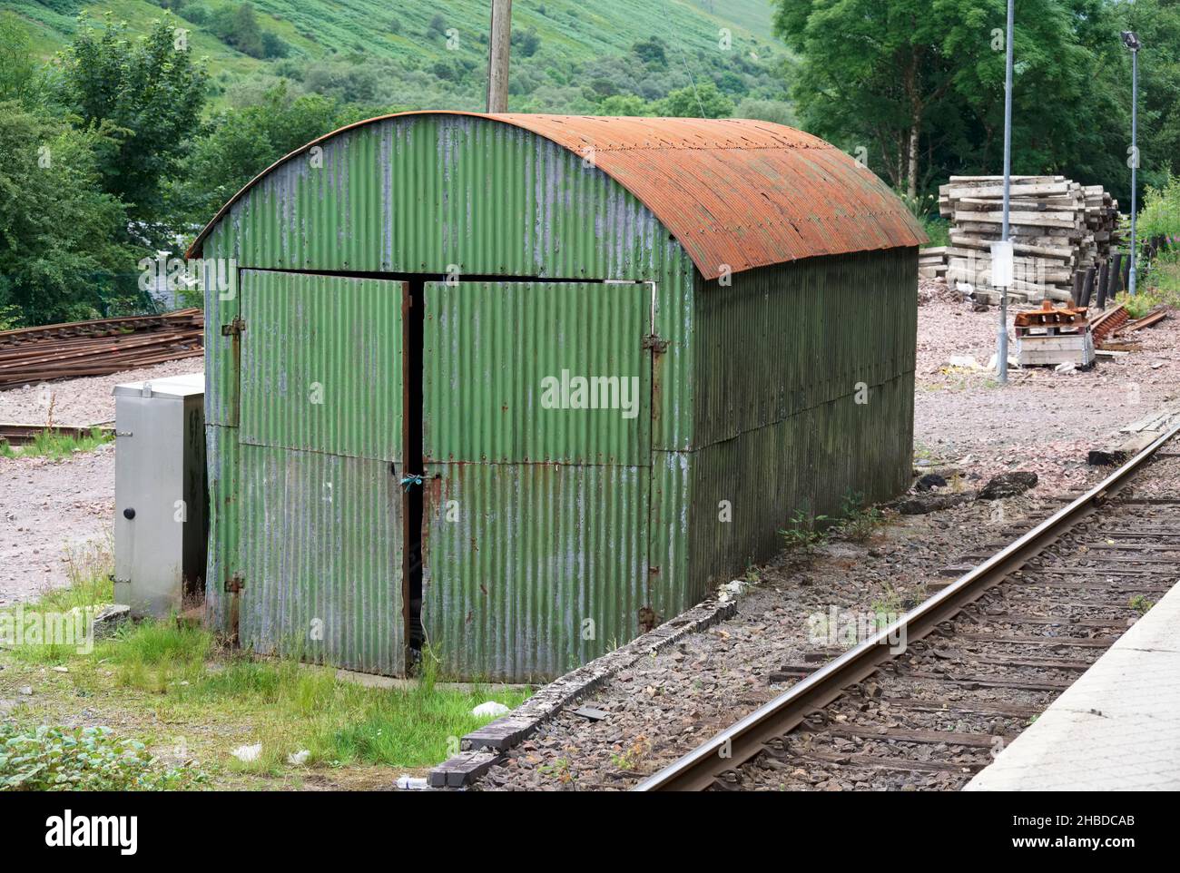 Capannone in ferro corrugato verde con tetto arrugato alla stazione ferroviaria Foto Stock