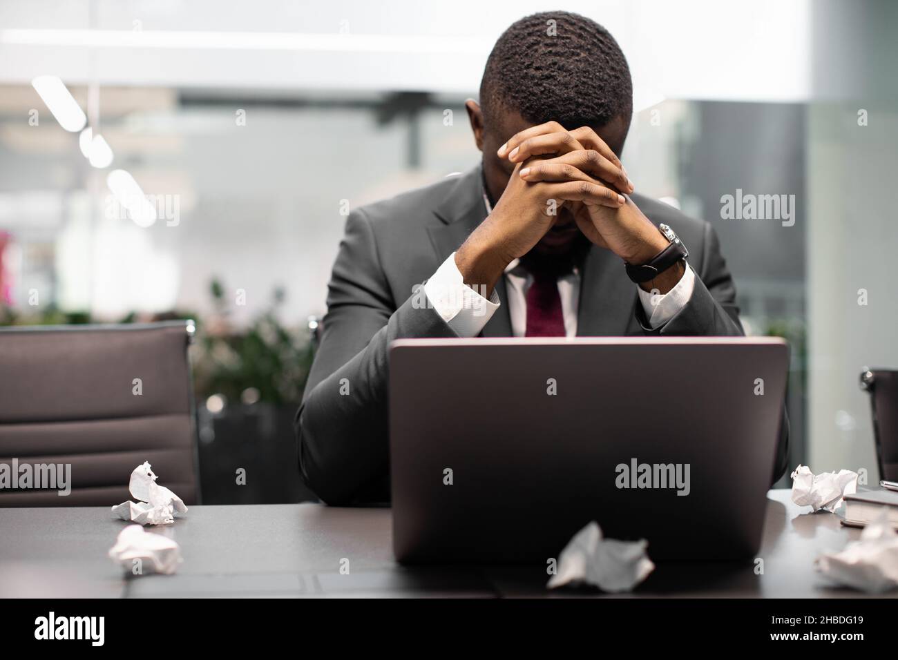 Stanco manager nero che soffre di burnout, lavorando su un notebook Foto Stock