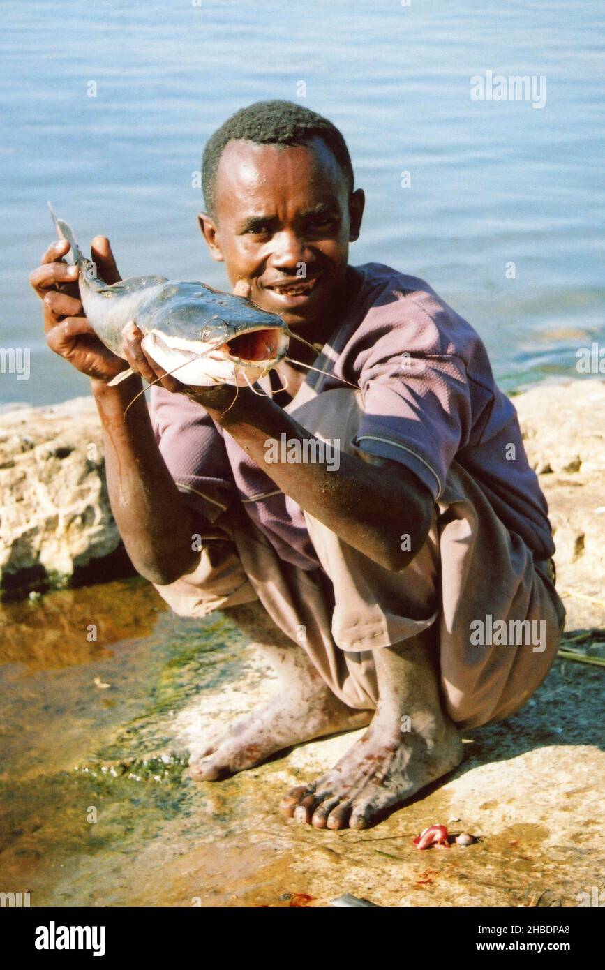 Pescatore Sidamo locale con pesce gatto africano (Clarias gariepinus) al lago Awasa (noto anche come lago Hawassa), Etiopia Foto Stock