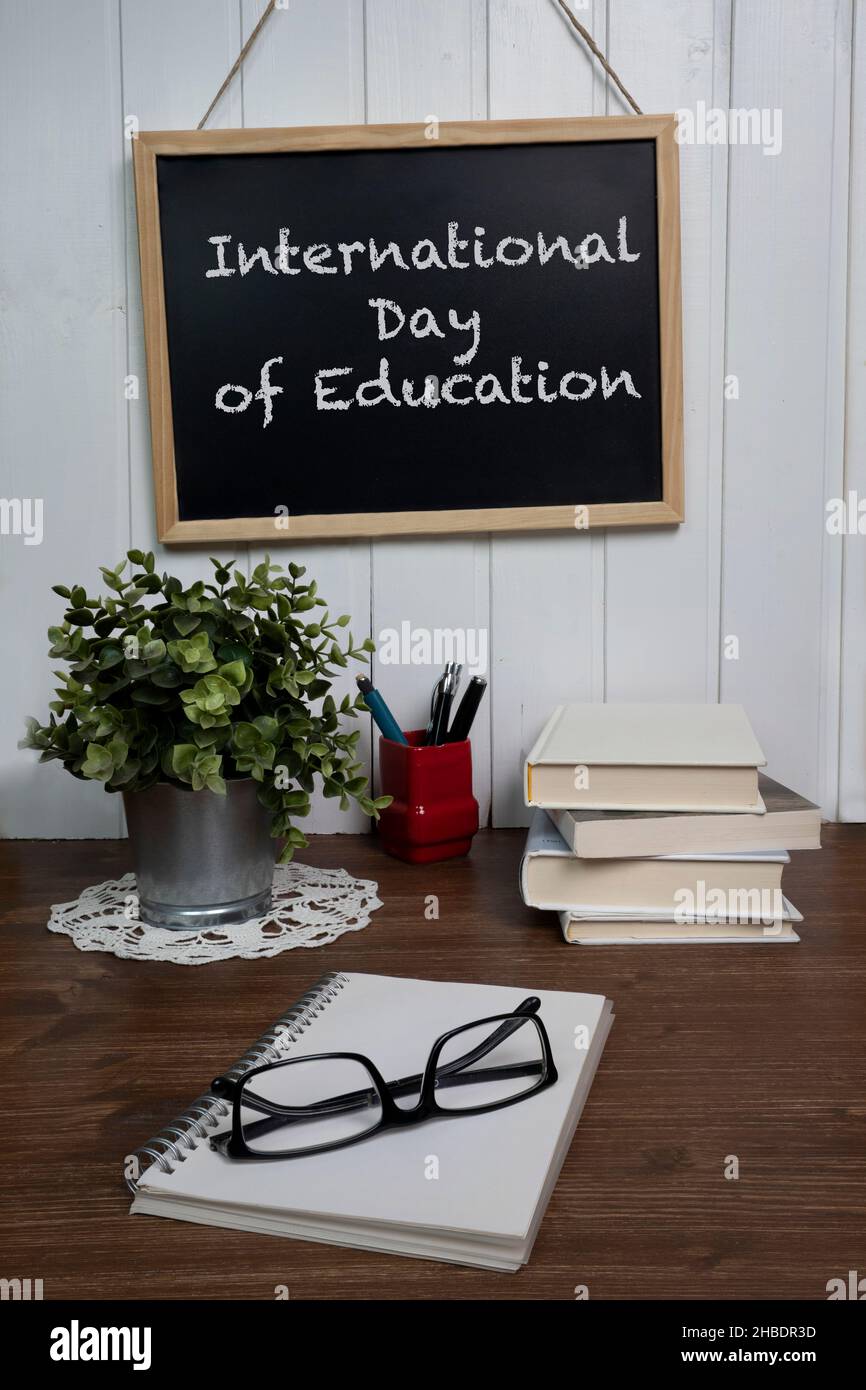 la rappresentazione della giornata internazionale dell'educazione con libri e un quaderno su un tavolo Foto Stock
