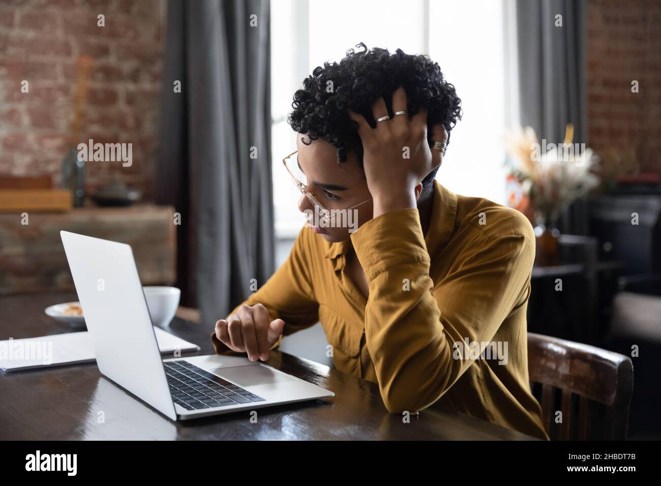 Infelice confuso donna afroamericana millenaria che lavora al computer. Foto Stock
