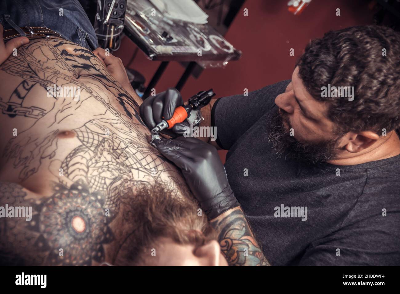 Il maestro tatuista disegna un salone tatuaggio Foto Stock