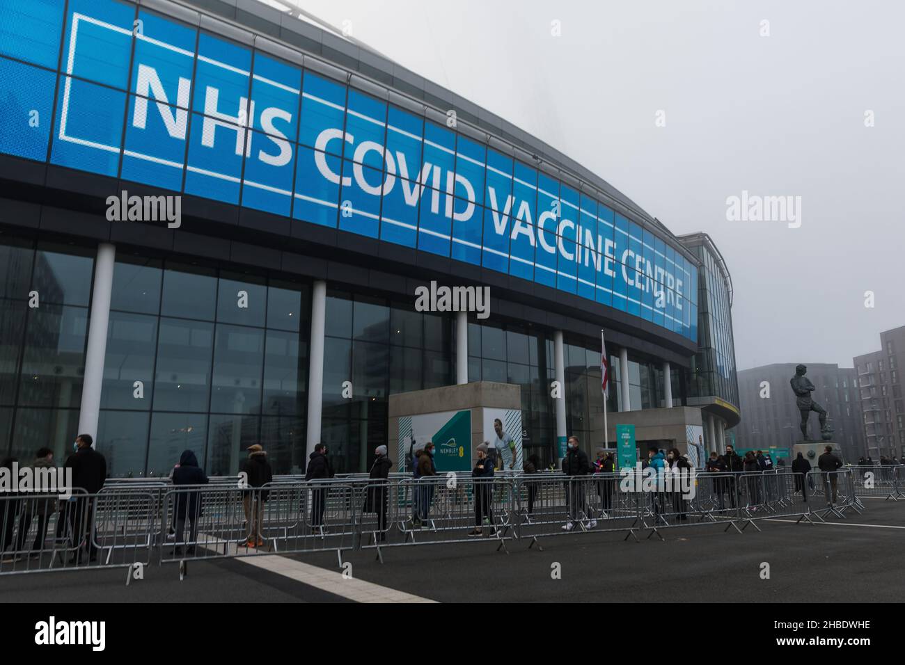 Wembley Stadium, Wembley Park, Regno Unito. 19th dicembre 2021. Centinaia di persone accodate all'esterno, presto la mattina di una nebbia Domenica, Wembley Stadium ospita una clinica di vaccino Covid pop up dal 10am al 6pm, con la prima e la seconda dose disponibili in aggiunta ai booster. Nel tentativo di aumentare la possibilità per i londinesi di ottenere i loro vaccini e booster Covid prima di Natale, lo stadio di calcio nazionale viene utilizzato come centro di vaccinazione di massa Covid. Amanda Rose/Alamy Live News Foto Stock