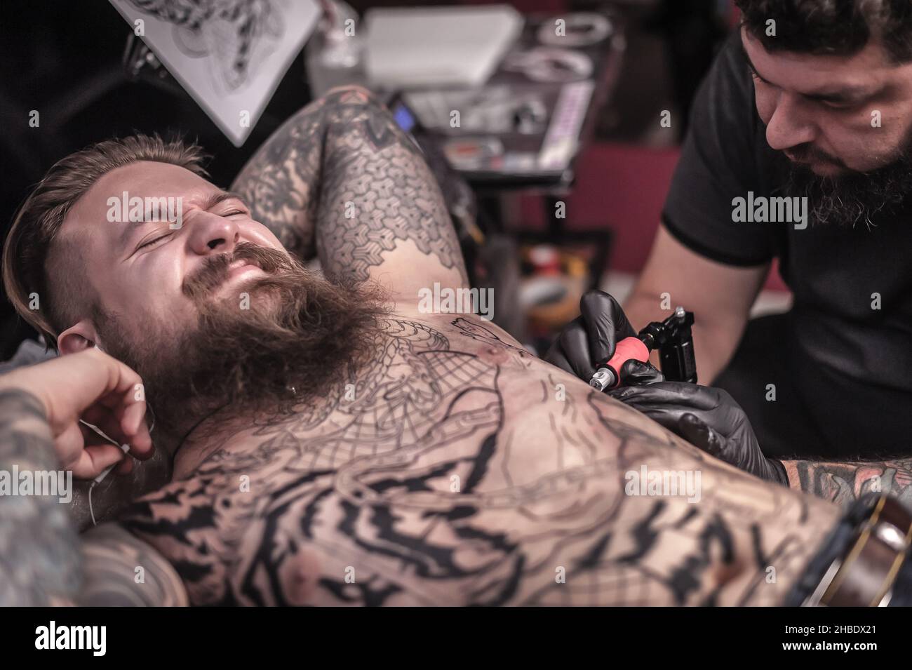 L'artista professionale del tatuaggio fa il tatuaggio freddo nello studio del tatuaggio Foto Stock