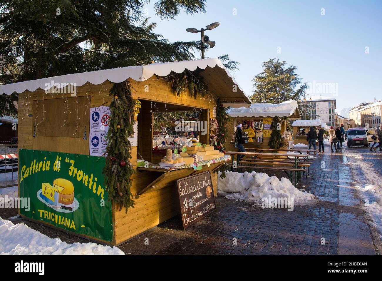 Belluno, Italia - Dicembre 11 2021. Una bancarella di formaggi in un tradizionale mercatino di Natale in Piazza dei Martiri nel centro storico durante la pandemia di Covid-19 Foto Stock