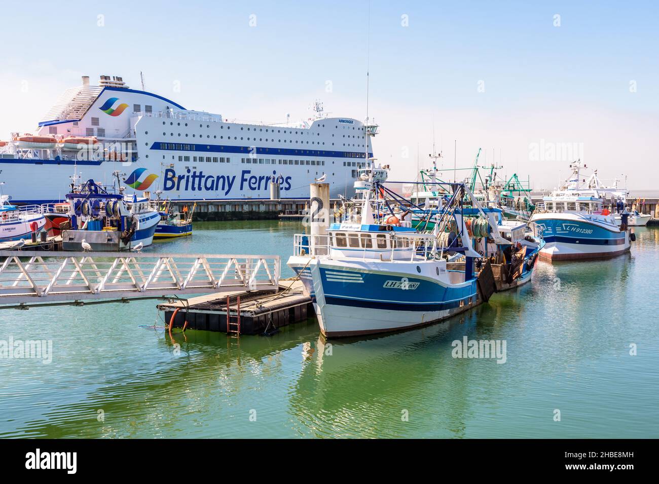 I pescherecci da traino ormeggiati nel porto di pesca di le Havre, Francia, accanto a un traghetto della compagnia Brittany Ferries. Foto Stock