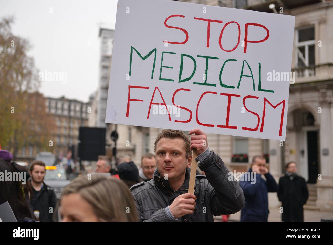 Un manifestante tiene un cartello che esprime la sua opinione, durante la manifestazione. I manifestanti anti anti anti anti-vaccino e anti-vaccino passano Uniti dagli oppositori delle restrizioni di Covid 19, si sono riuniti a Parliament Square e hanno marciato attraverso il centro di Londra. Foto Stock
