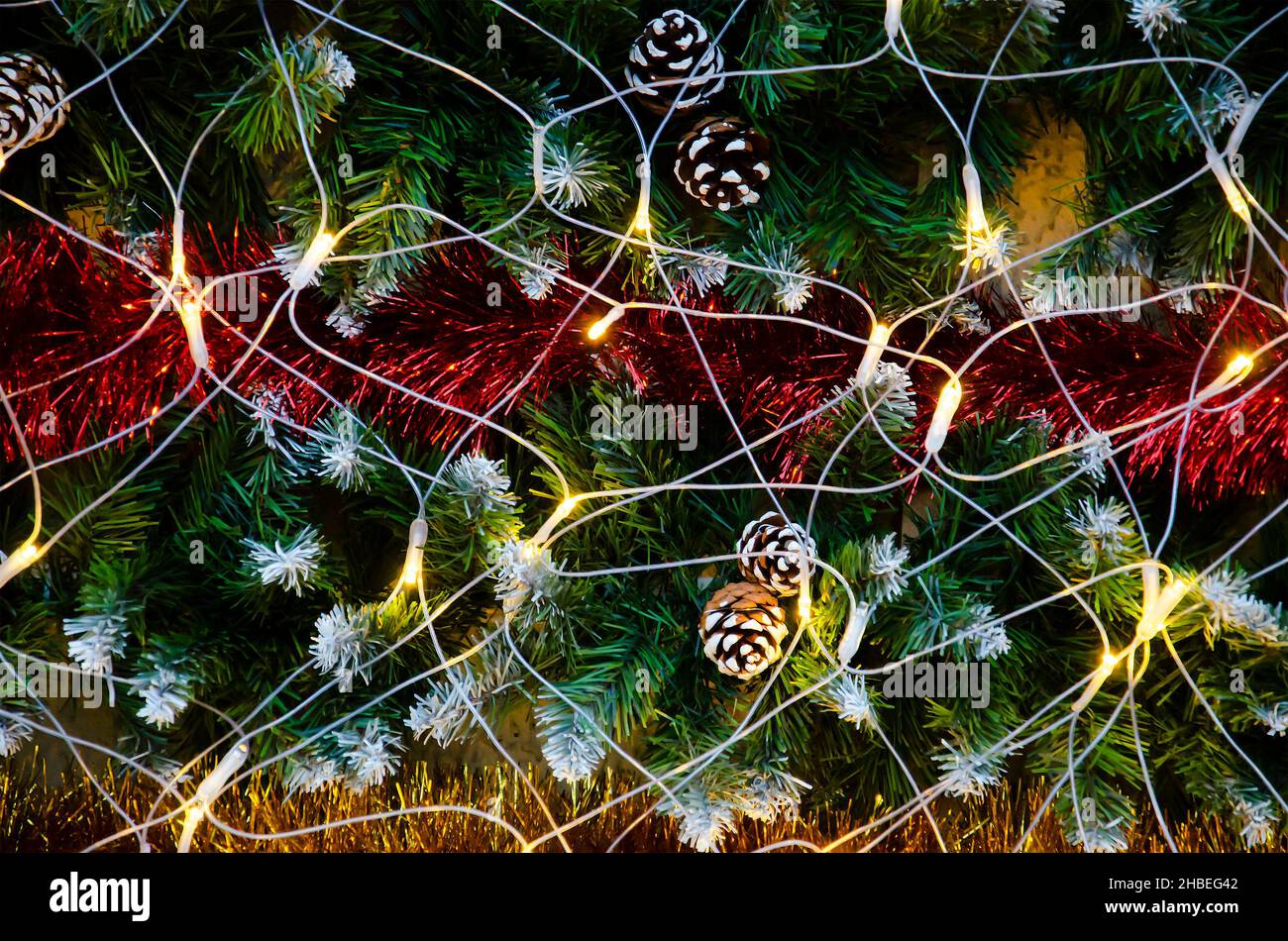Decorazione di Natale sull'albero di abete. Luci scintillanti, coni di pino, Natale, tinsel multicolore. Sfondo. Primo piano. Foto Stock