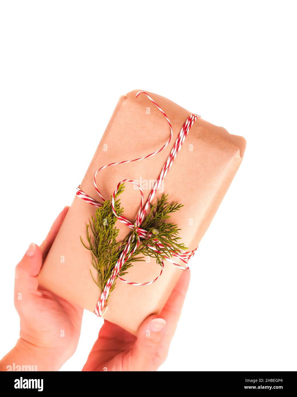 Mani con scatola regalo avvolta in carta artigianale su sfondo bianco Foto Stock