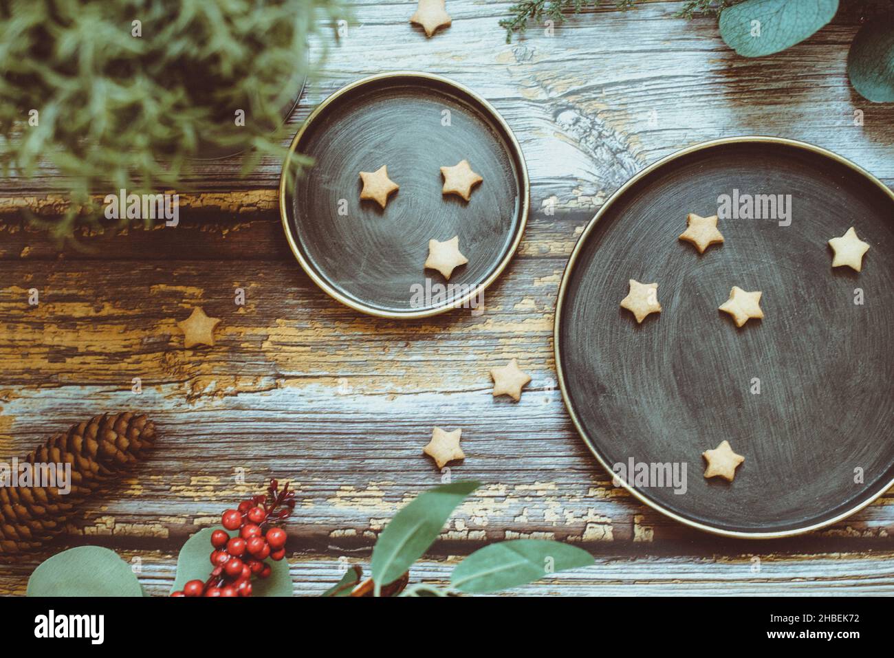 Vista dall'alto dei biscotti natalizi a forma di stella su un tavolo di legno con decorazioni natalizie Foto Stock