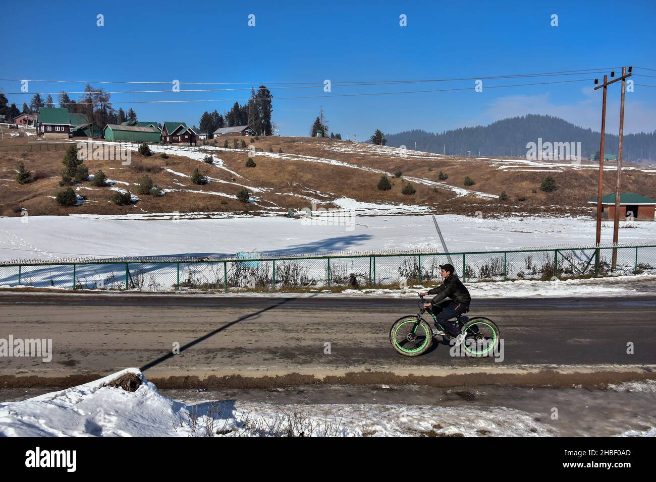 Gulmarg, India. 19th Dic 2021. Un ciclista corre lungo una strada durante una fredda giornata invernale in una famosa stazione sciistica di Gulmarg, a circa 55kms da Srinagar. Credit: SOPA Images Limited/Alamy Live News Foto Stock