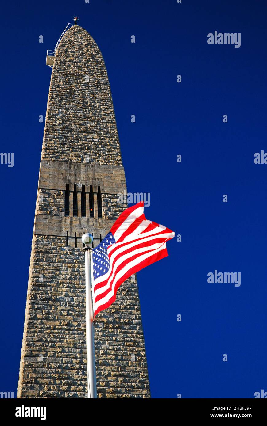 Una bandiera americana ondeggia di fronte al Bennington Battle Monument in Vermont. L'obelisco onora i Green Mountain Boys della Rivoluzione americana Foto Stock