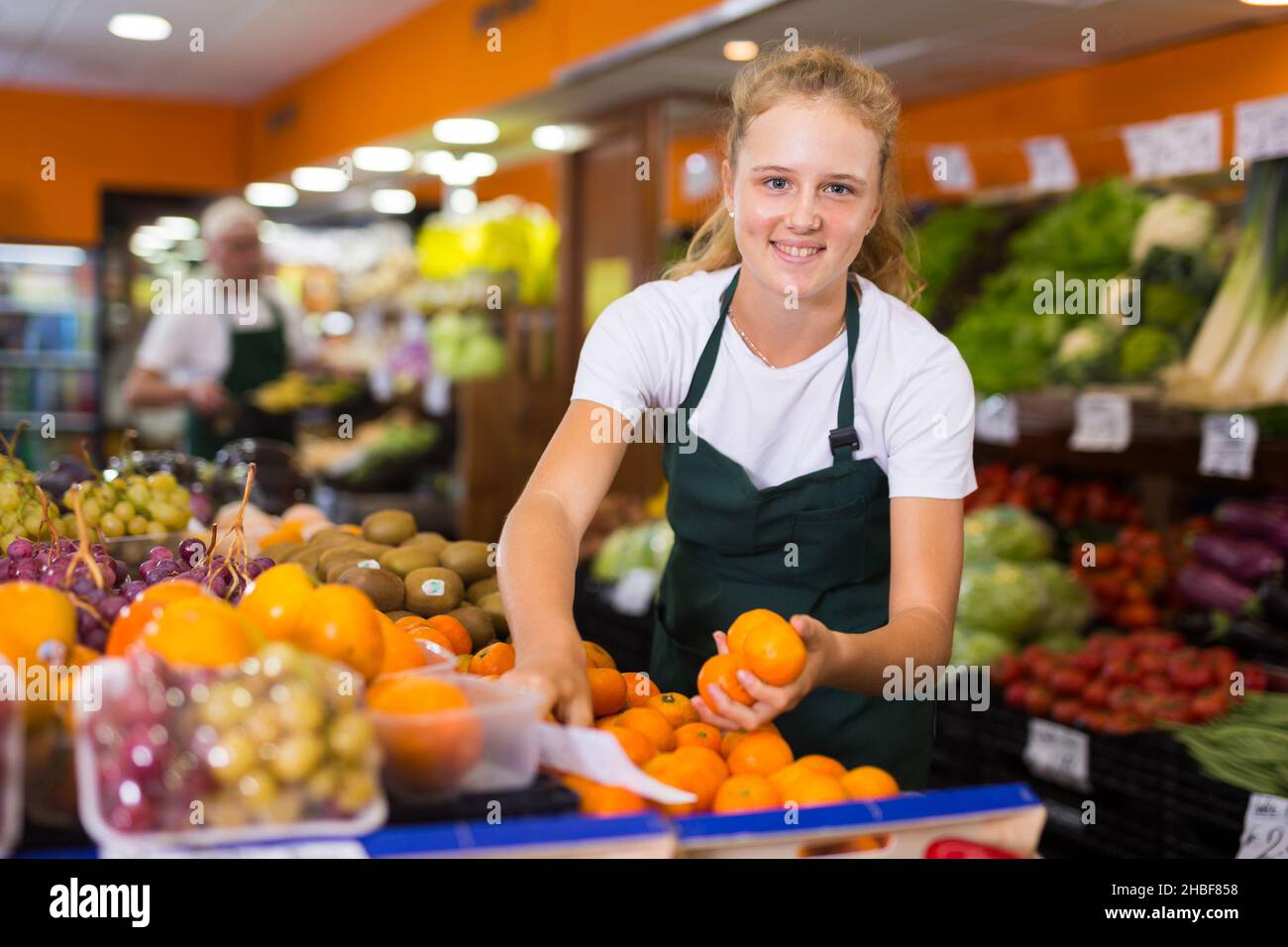 Ragazza al suo primo lavoro in negozio di verdure Foto Stock