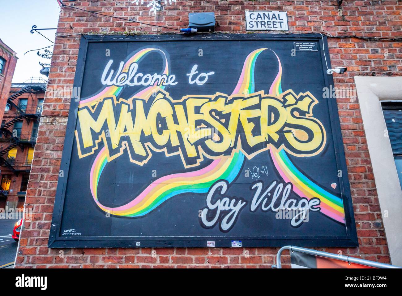 Cartello su un edificio in Canal Street, Manchester, che accoglie la gente al 'villaggio gay', situato vicino all'incrocio di Chorlton Street Foto Stock