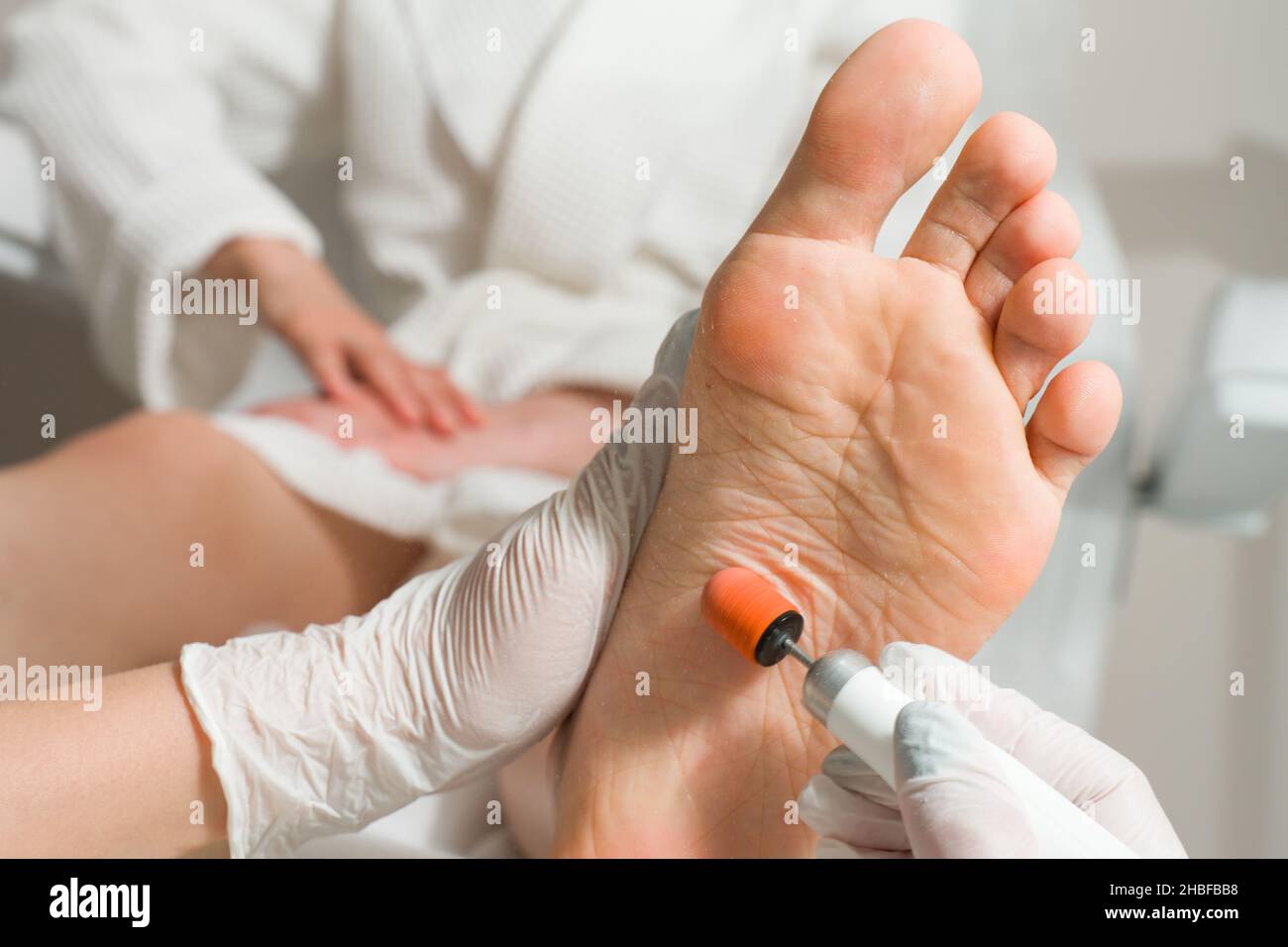 Medico di Podiatrist, esegue la procedura di trattamento delle gambe di una donna. Procedure cosmetiche dei piedi Foto Stock