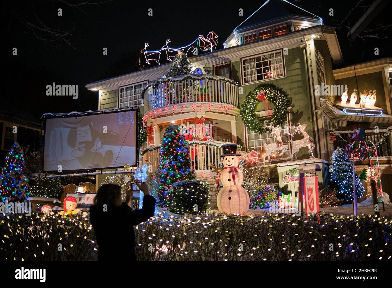 Halifax, Nuova Scozia, Canada. Dicembre 19th, 2021. Due fratelli Halifax South End stanno continuando la loro tradizione di grandi esposizioni di luce di Natale per la gioia dei bambini giovani e vecchi su Connaught Street. I fratelli Giocomantonio hanno iniziato la tradizione festiva più di 15 anni fa, e ora si è evoluto in un must-SEE per tutti nella città. Con una nuova caduta di 5cm di neve, le famiglie si sono incappate a vedere le luci all'inizio di quella che sarà di nuovo una stagione di vacanze sottomesse con l'impatto della pandemia che porta a nuove restrizioni in provincia. Credit: Meanderingemu/Alamy Live News Foto Stock