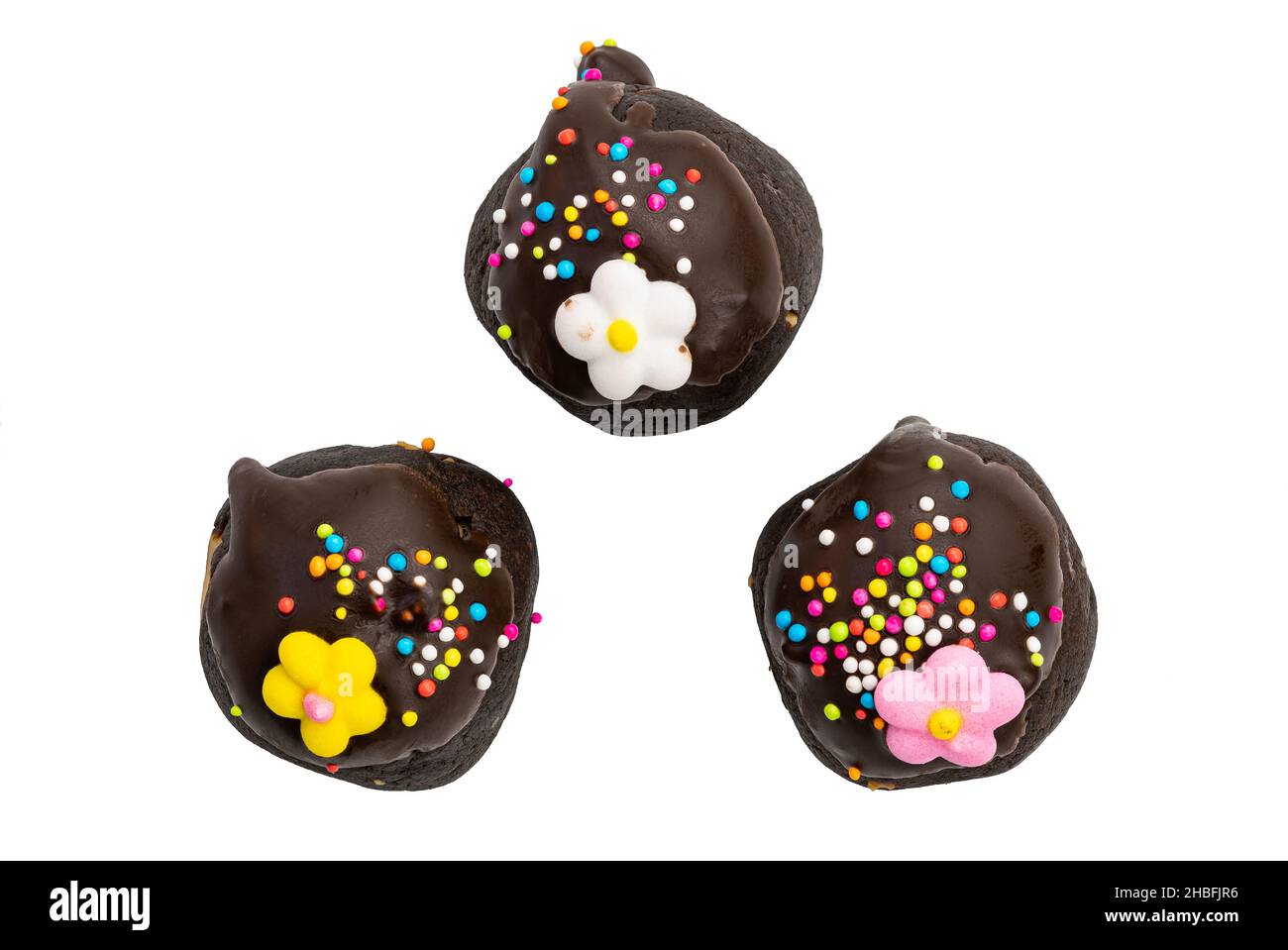Vista dall'alto di deliziose palle di cioccolato con spruzzi di arcobaleno e fiori di zucchero su sfondo bianco con percorso di taglio. Foto Stock