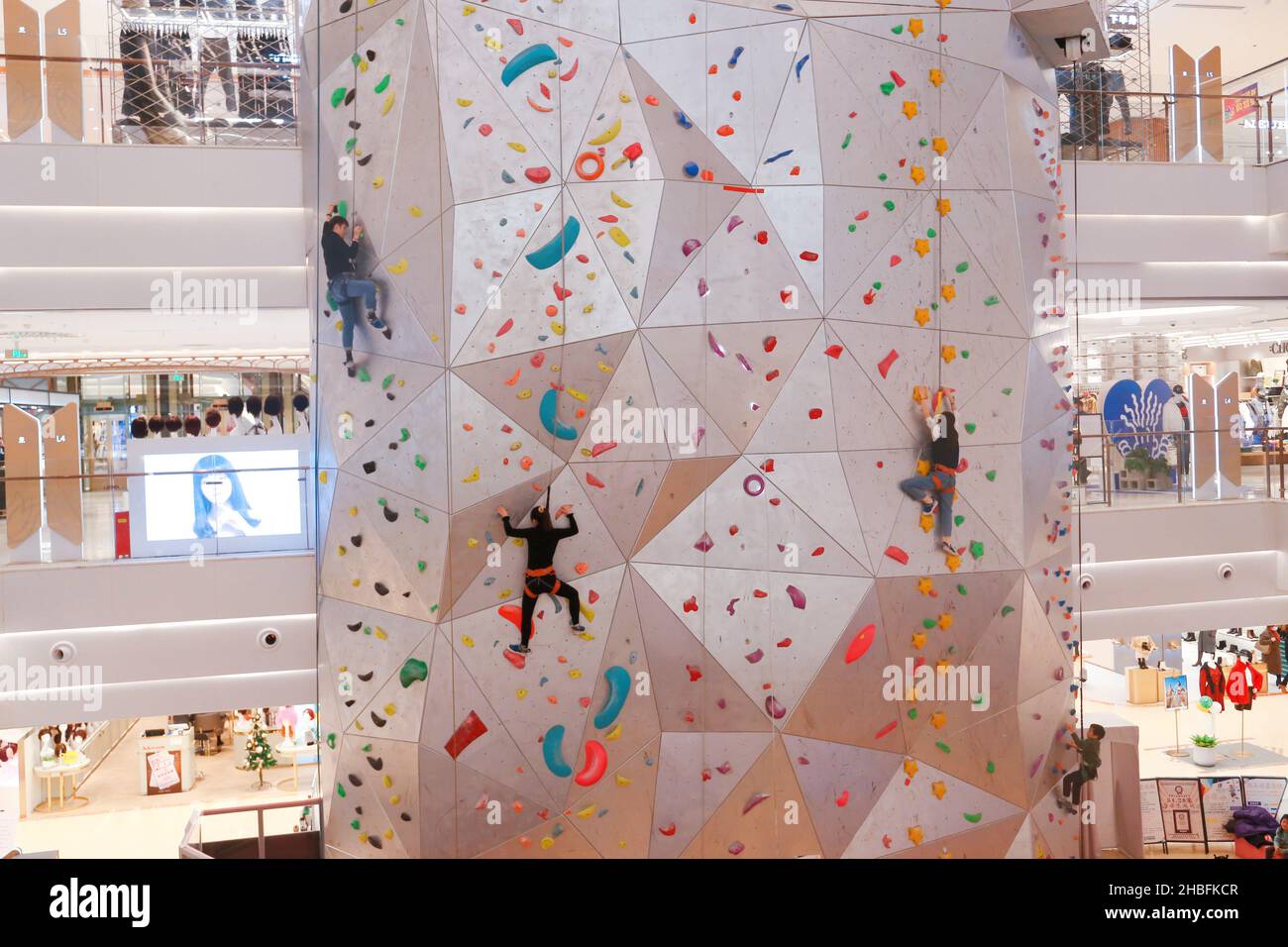 SHANGHAI, CINA - 19 DICEMBRE 2021 - gli appassionati di fitness invernali possono sperimentare la parete di arrampicata al coperto più alta del mondo al New World Mall, una com Foto Stock