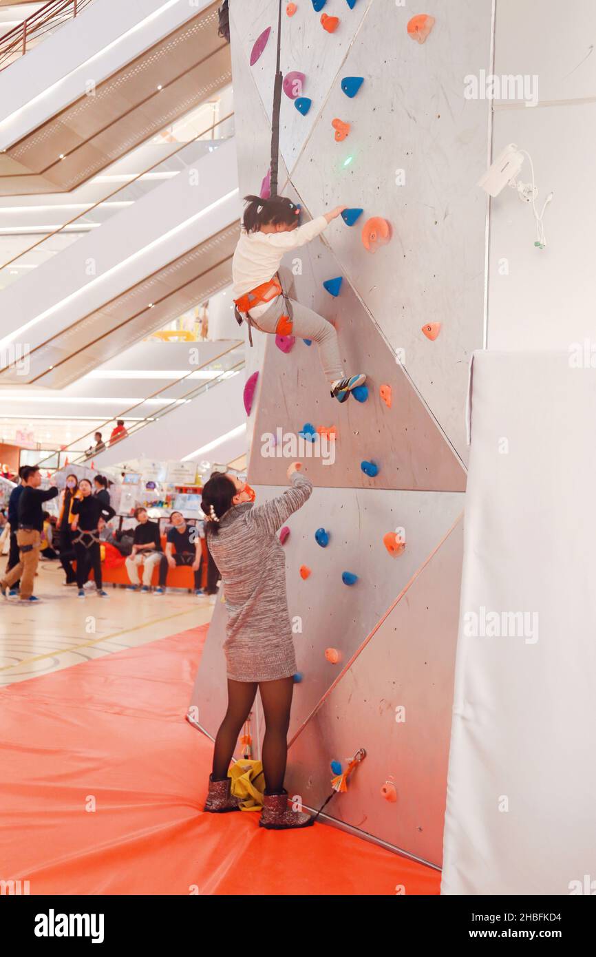 SHANGHAI, CINA - 19 DICEMBRE 2021 - gli appassionati di fitness invernali possono sperimentare la parete di arrampicata al coperto più alta del mondo al New World Mall, una com Foto Stock