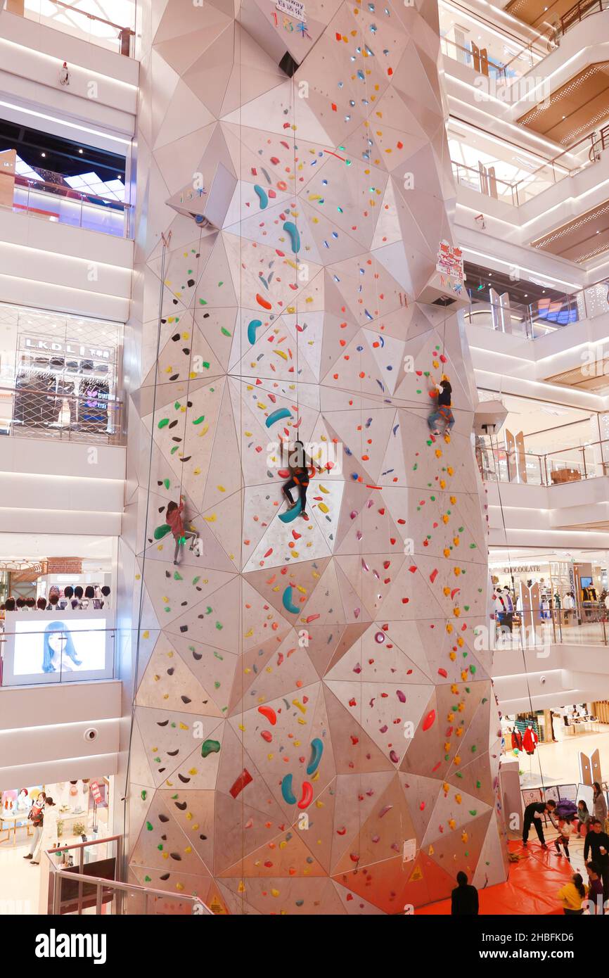 SHANGHAI, CINA - 19 DICEMBRE 2021 - gli appassionati di fitness invernali possono sperimentare la parete di arrampicata al coperto più alta del mondo al New World Mall, una com Foto Stock