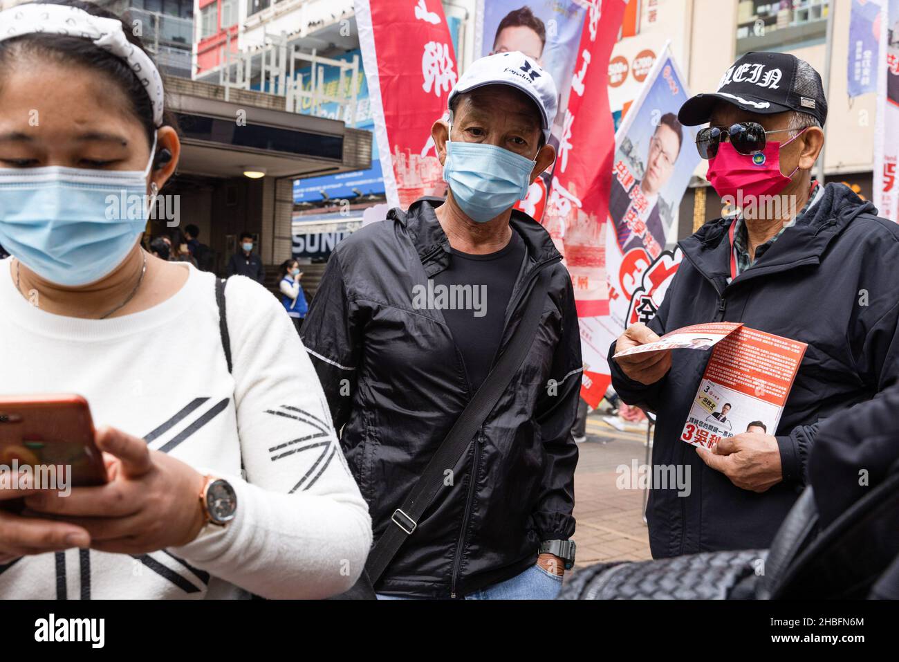 Un uomo ha visto distribuire volantini di candidato pro-Cina (Stanely ng Chau-pei) in WAN Chai.le elezioni generali del Consiglio legislativo del 2021 si sono tenute il 19 dicembre, come tasso di affluenza alle urne del 30,2 per cento nelle elezioni, il più basso dal 1997 come candidati pro-Cina o pro-establishment vincendo una vittoria schiacciante. Questa è la prima grande elezione del consiglio legislativo dopo la riforma del sistema elettorale, un grave giro di vite sui partiti pro-democratici e l'istituzione della legge sulla sicurezza nazionale di Hong Kong, con l'introduzione del Comitato per la revisione dell'eleggibilità candidato per garantire solo i patrioti candida Foto Stock